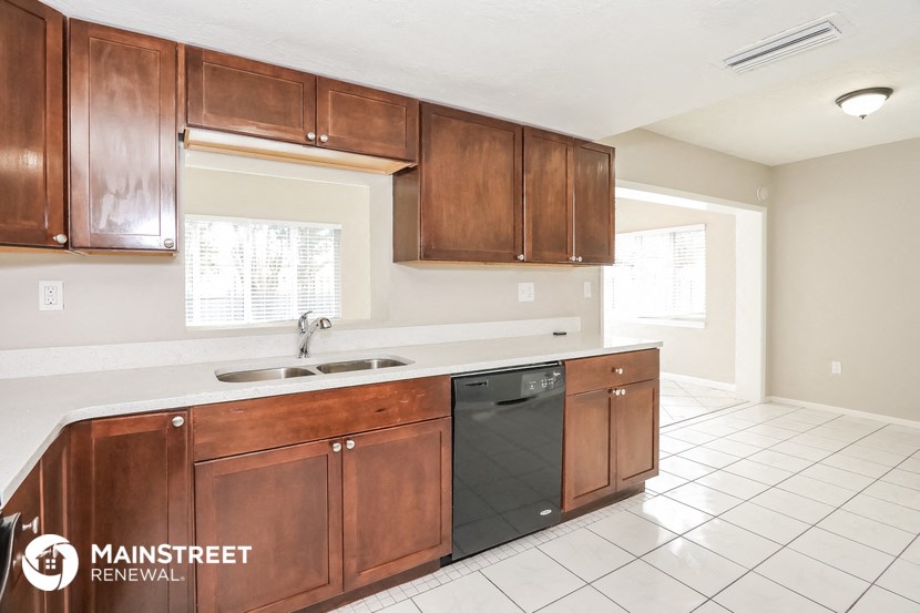 a kitchen with wooden cabinets and a sink and a dishwasher