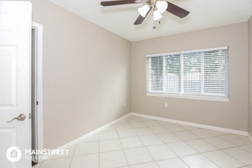 an empty room with a ceiling fan and a window