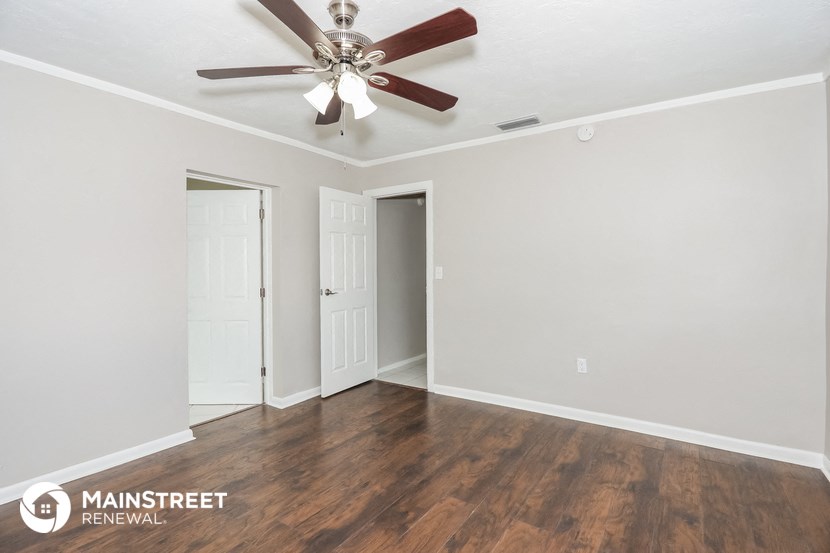 the living room of an empty renovated house with a ceiling fan