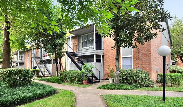 a brick apartment building with stairs and trees
