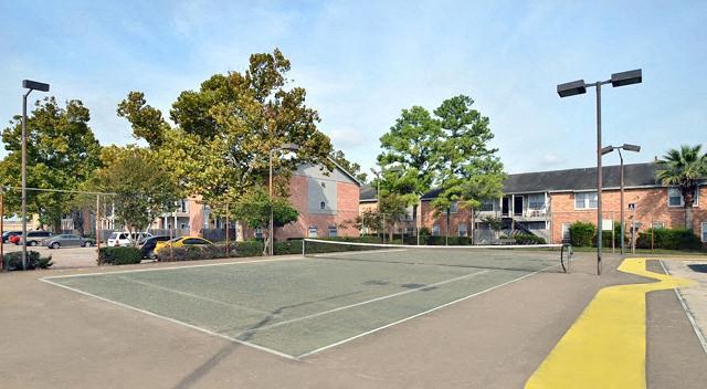 a tennis court in the middle of a parking lot