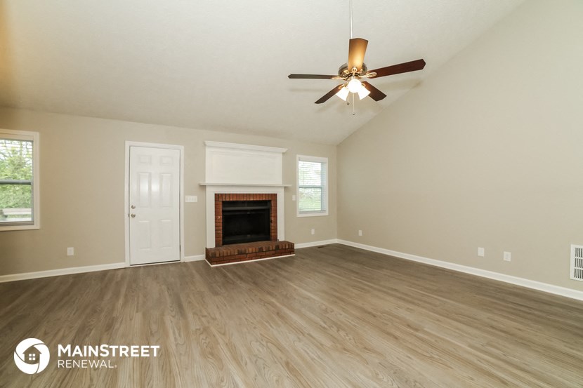 the living room with fireplace and ceiling fan