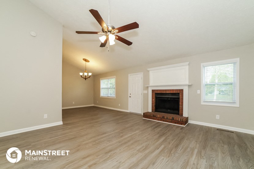 the living room with fireplace and ceiling fan