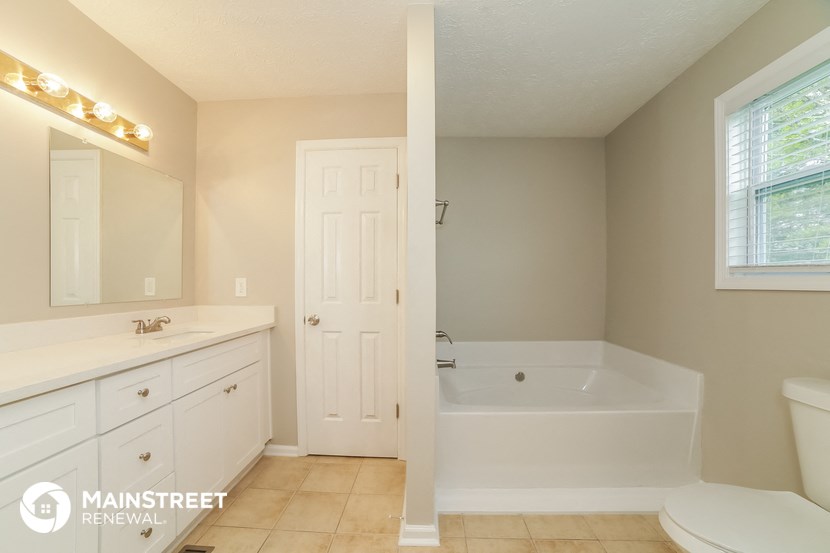 a bathroom with a tub and a sink and a mirror