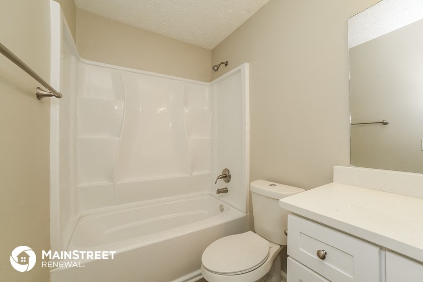 a bathroom with a tub and a toilet and a sink
