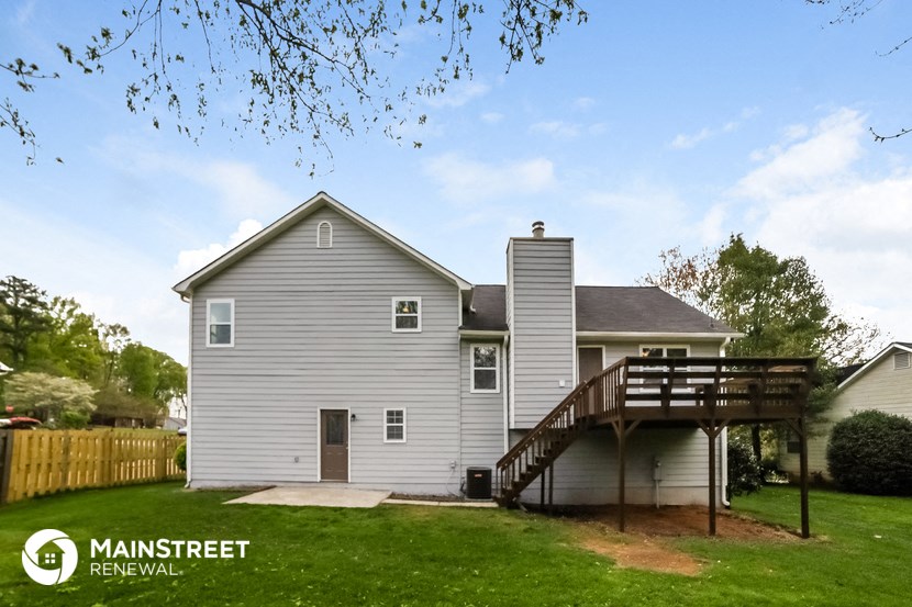 a gray house with a deck on the back of it