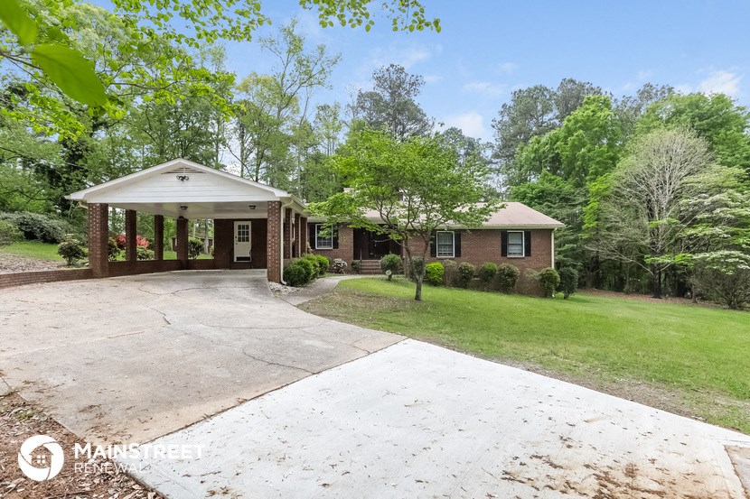 a brick house with a concrete driveway and a porch