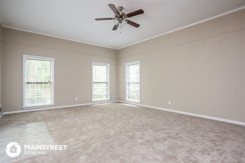 an empty living room with a ceiling fan