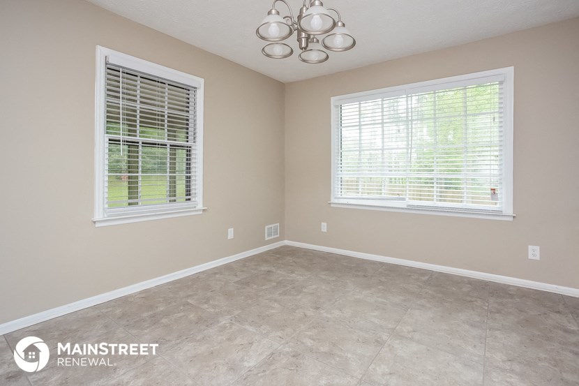 a empty room with two windows and a tile floor