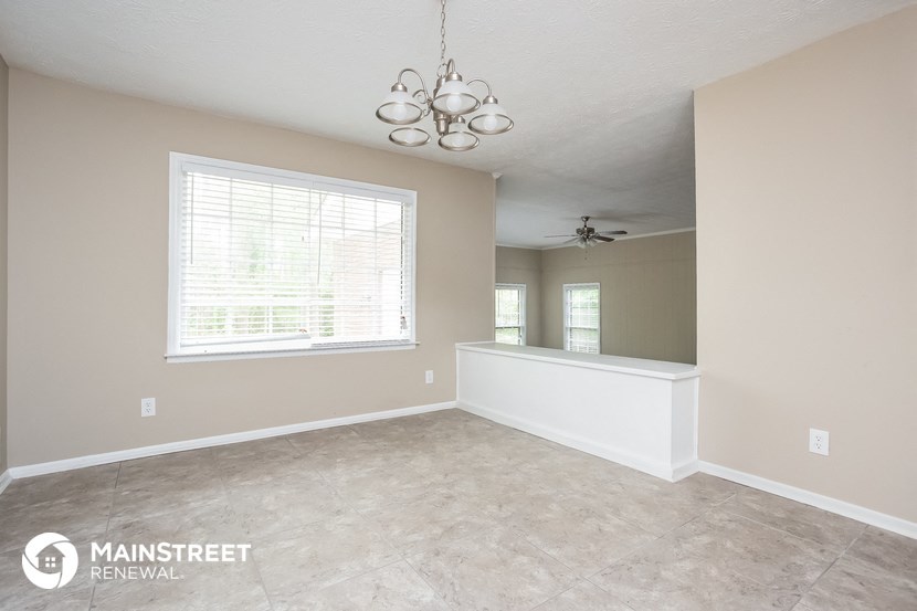 the dining room and kitchen of a home with a large window