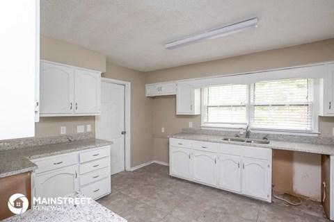 a kitchen with white cabinets and counters and a sink