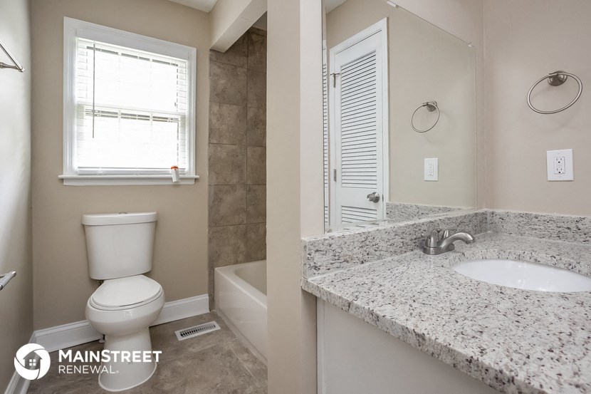 a bathroom with a toilet and a sink and a mirror