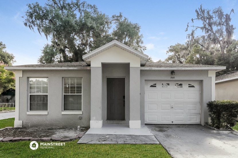 a white house with a white garage door and a lawn