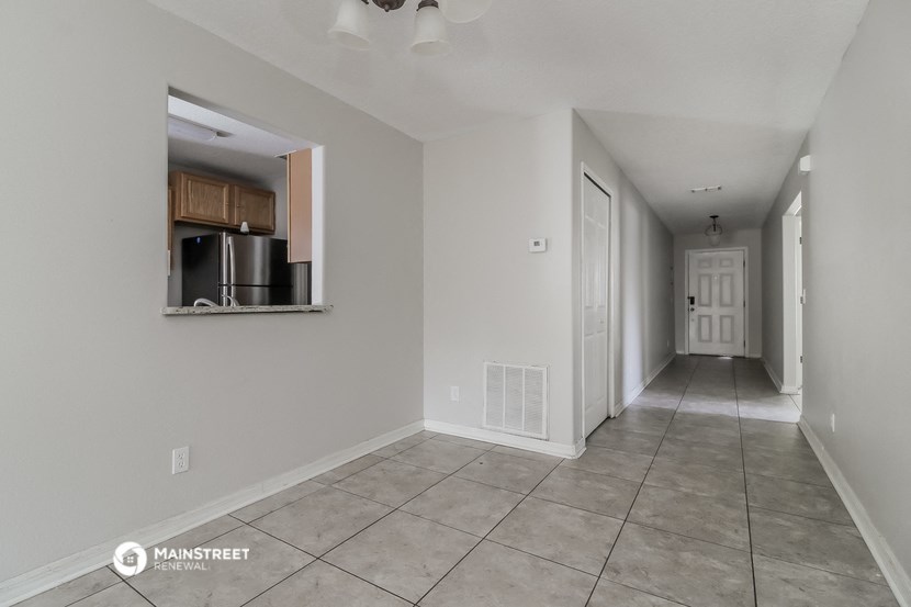 the living room and hallway of an empty apartment