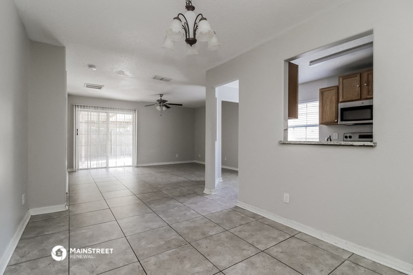 an empty kitchen and living room with a ceiling fan