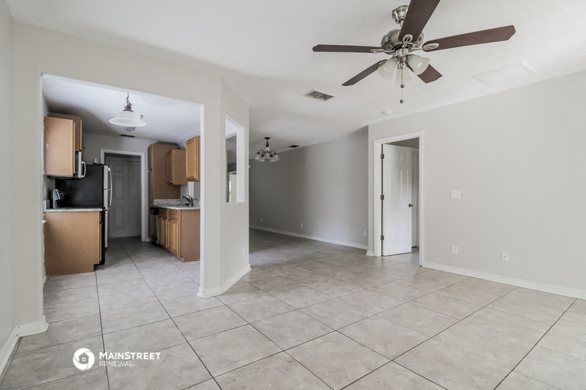 an empty kitchen and living room with a ceiling fan