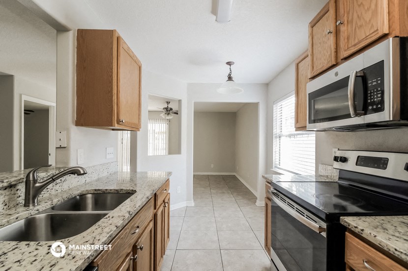 a kitchen with granite counter tops and wooden cabinets