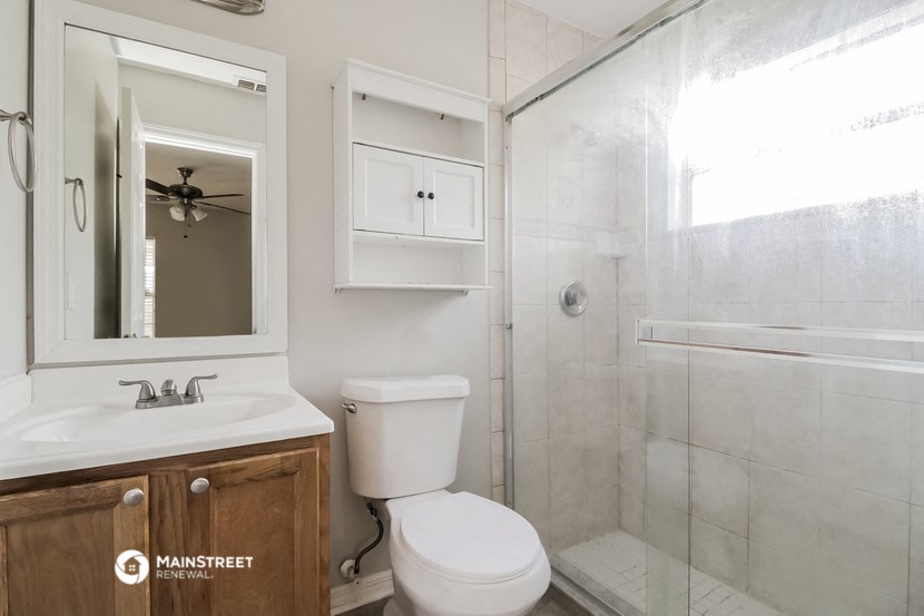 a bathroom with a shower and a sink and a toilet