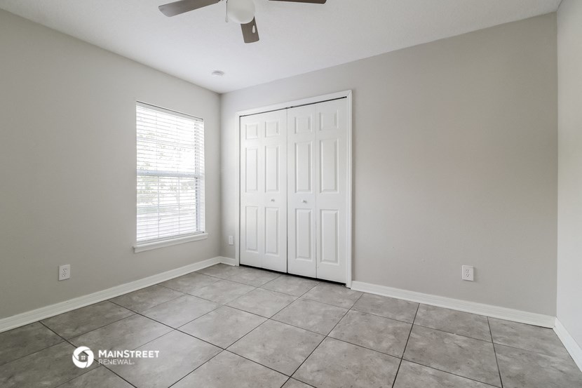 the living room of a home with a tile floor and a white door