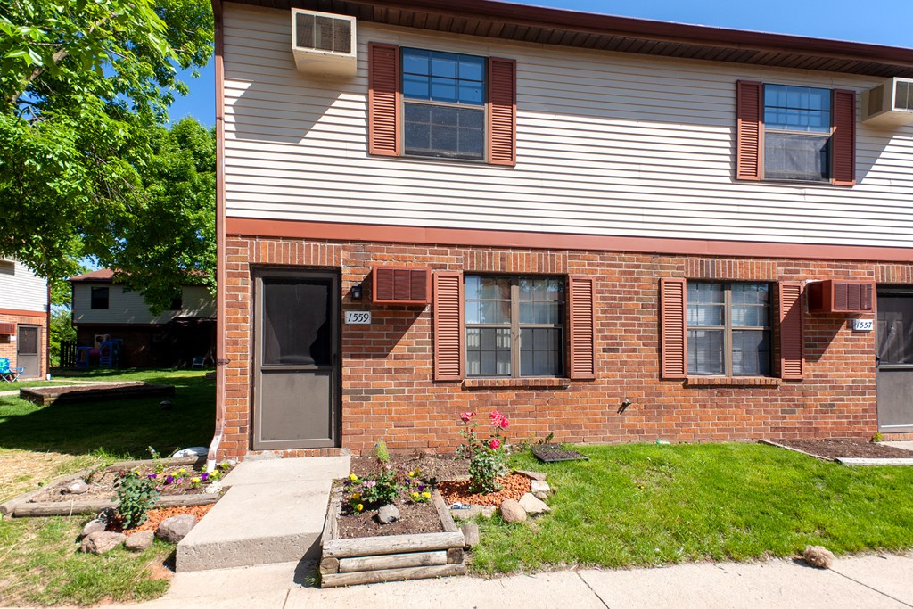 the side of a house with a sidewalk in front of it