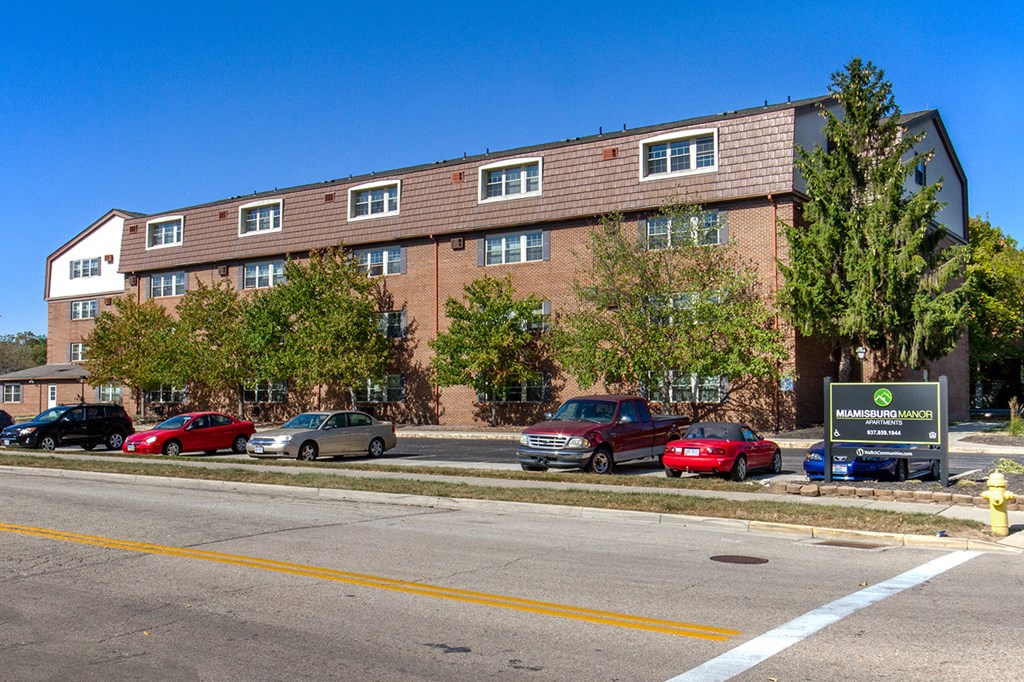 a large brick building with cars parked in front of it
