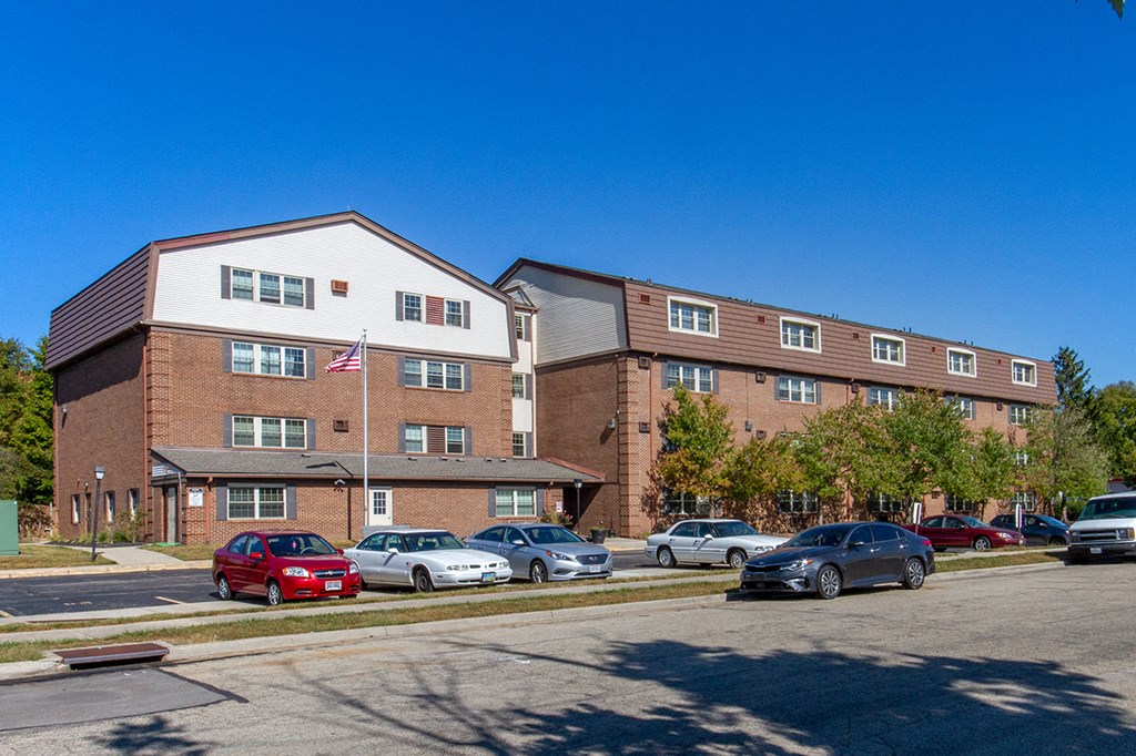 a large brick building with cars parked in a parking lot