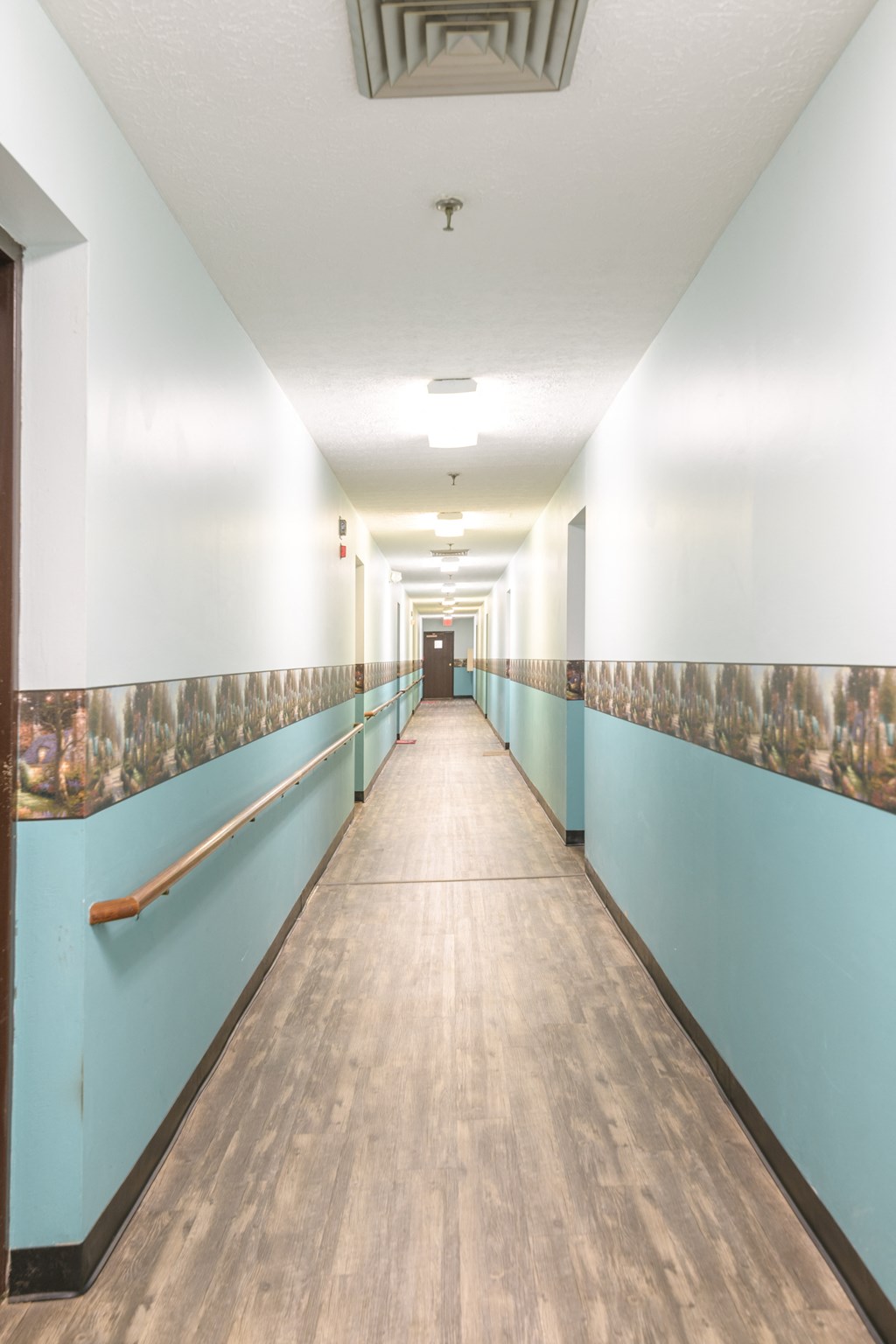 a long hallway with blue and white walls and wood floors