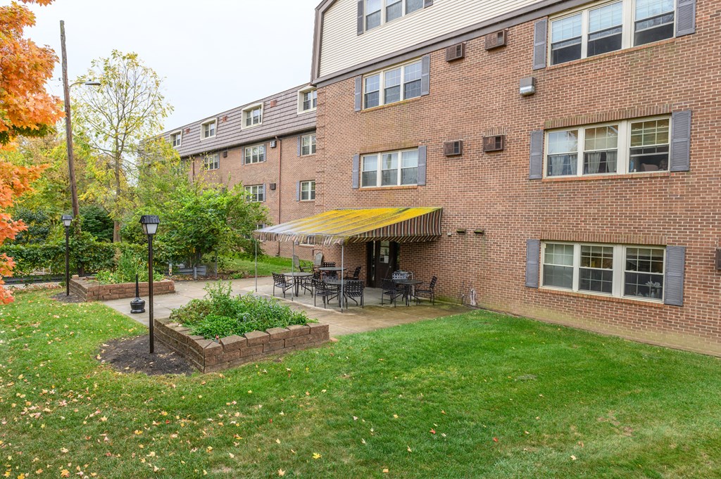 the backyard of a brick apartment building with a patio
