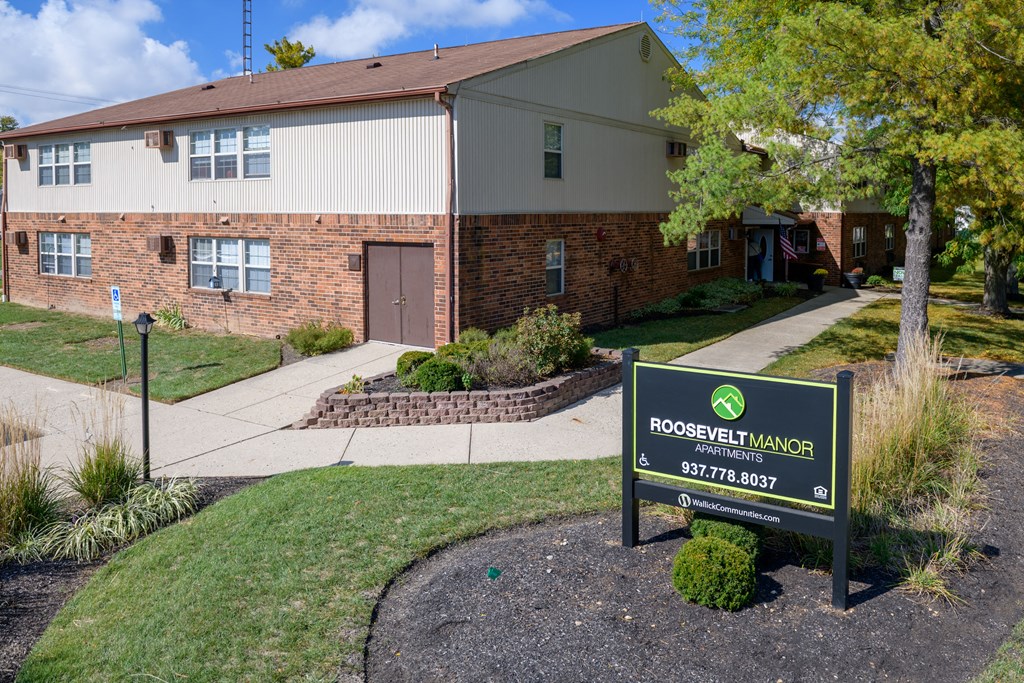 an apartment building with a sign in front of it