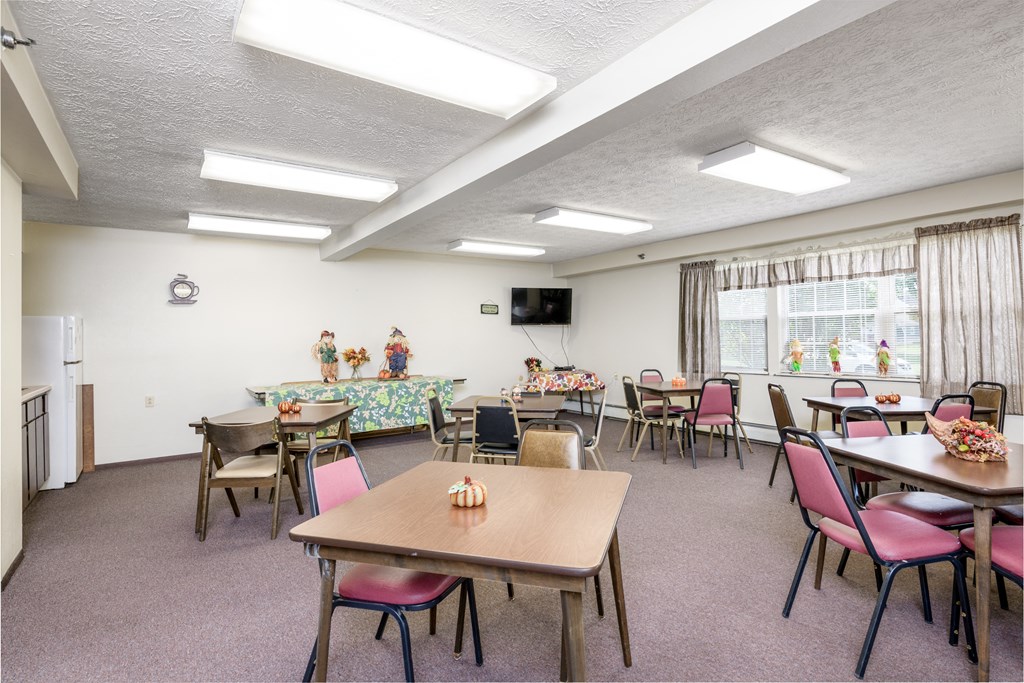 a dining room with tables and chairs and a television