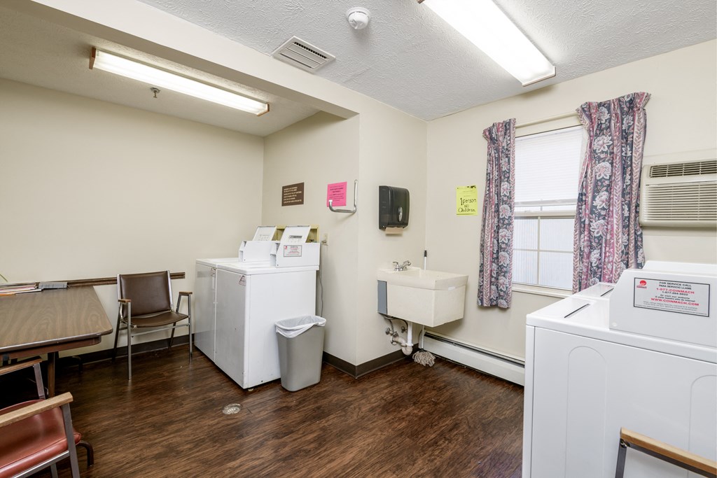 a laundry room with washers and dryers and a sink