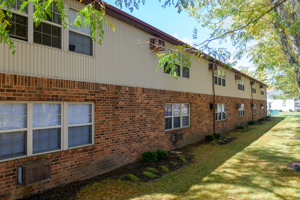 an exterior view of a brick building with trees