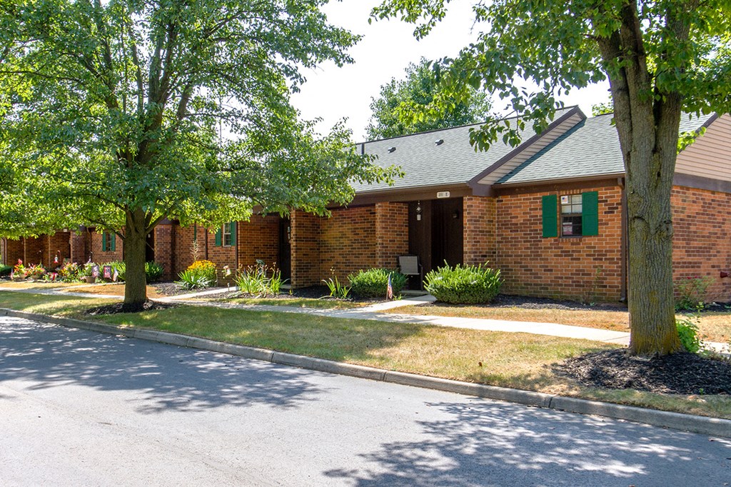 the front of a brick building with trees