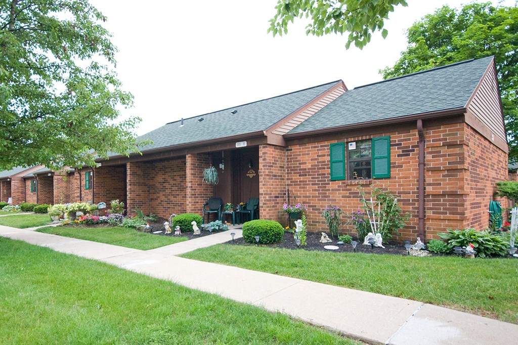 a brick house with a sidewalk in front of it