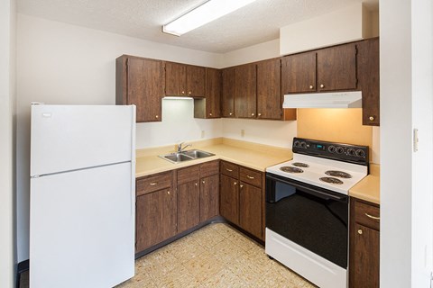 a kitchen with white appliances and wooden cabinets