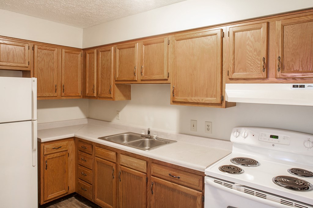 a kitchen with white appliances and wooden cabinets