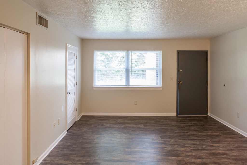 an empty living room with a window and a door