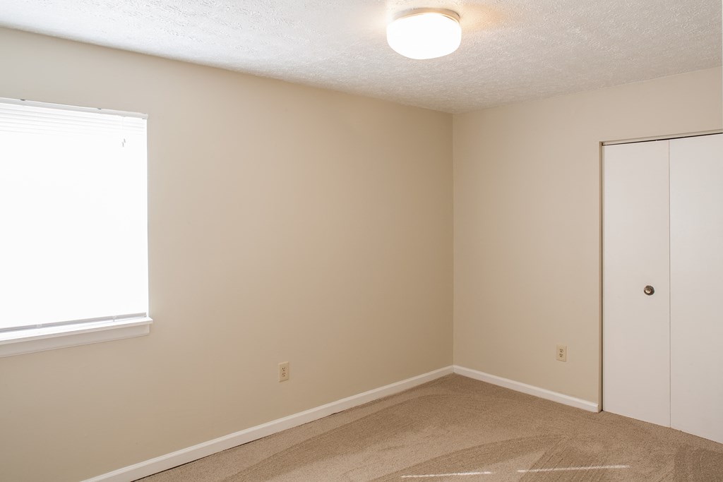 an empty room with a door and a window