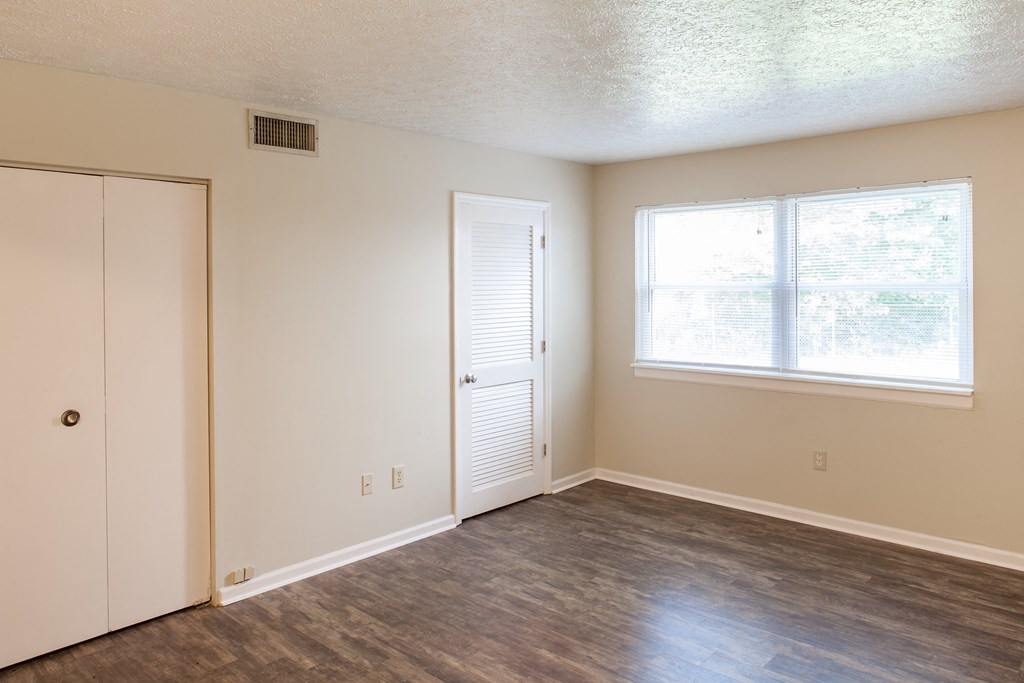 an empty living room with a door and a window