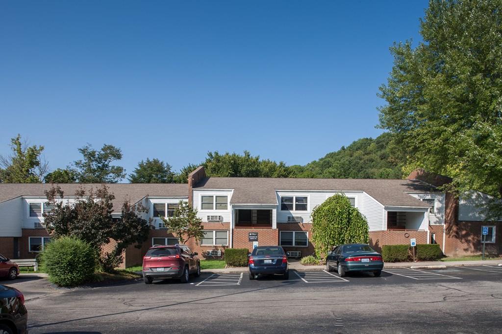 an apartment building with cars parked in a parking lot