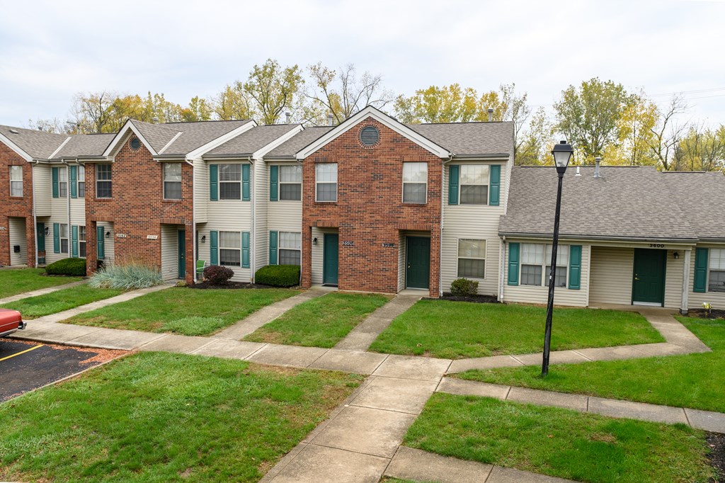 a row of town homes with sidewalks and grass