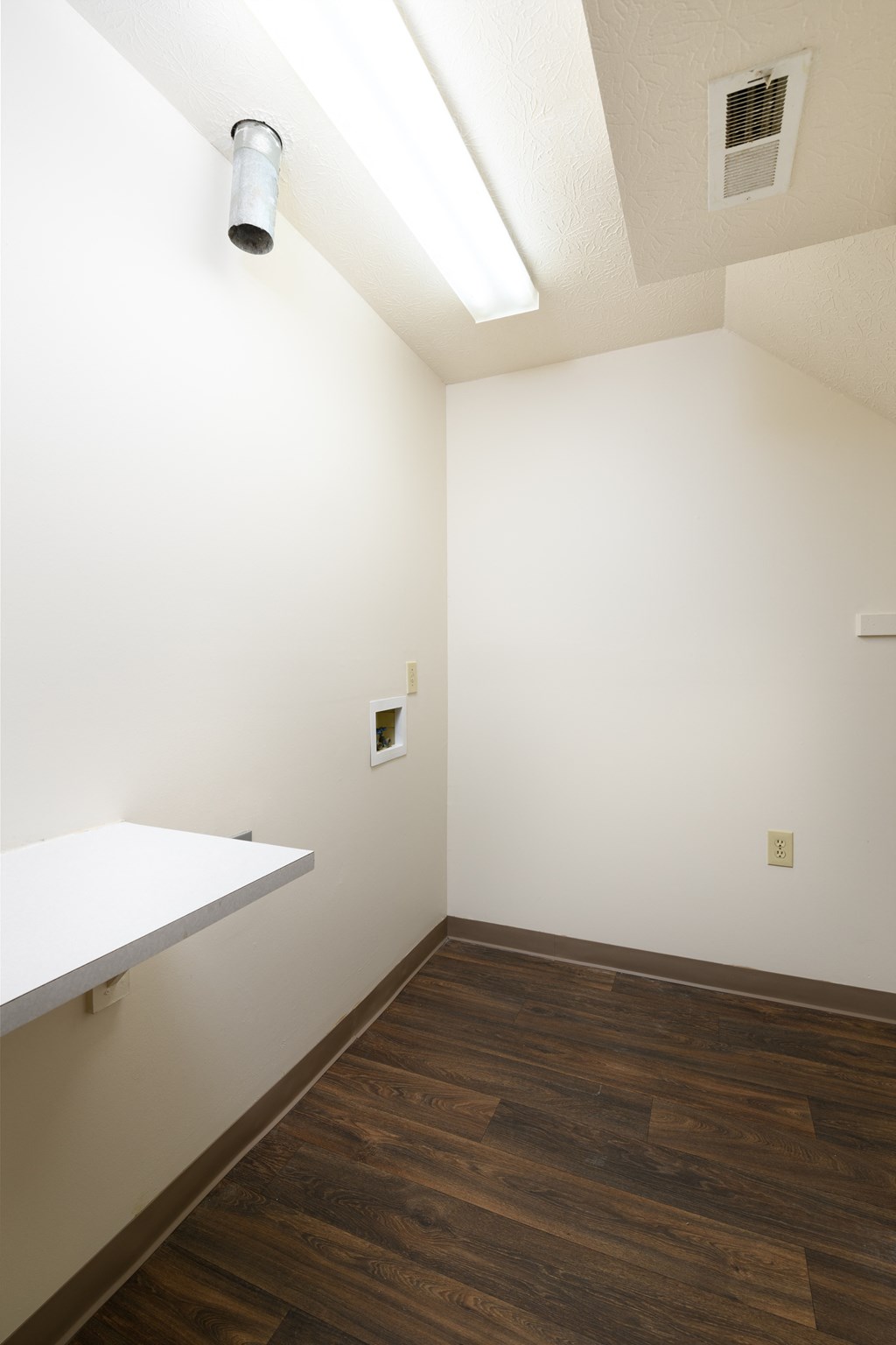 an empty room with white walls and wood floors