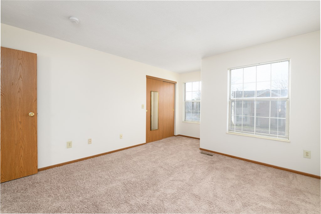 an empty living room with a window and a door