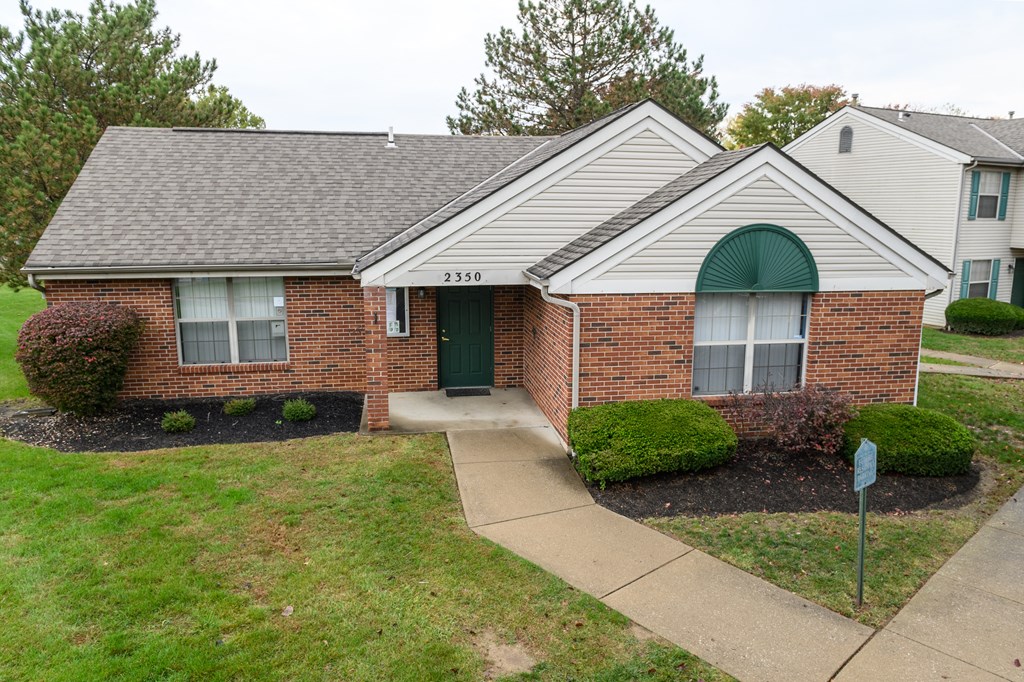 the front of a brick house with a green door