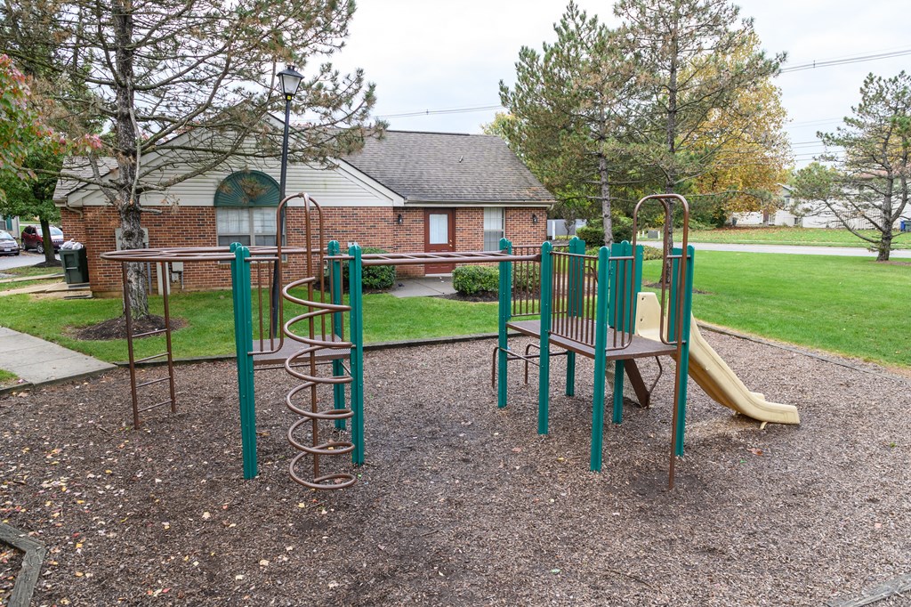 a playground in a park in front of a house
