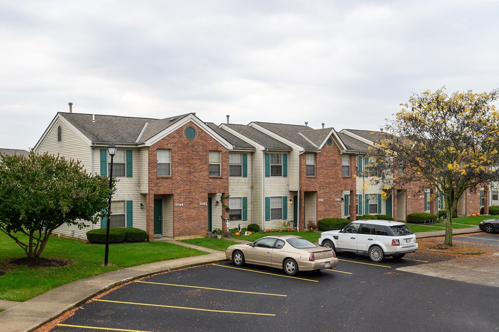 a row of apartment buildings with cars parked in front of them