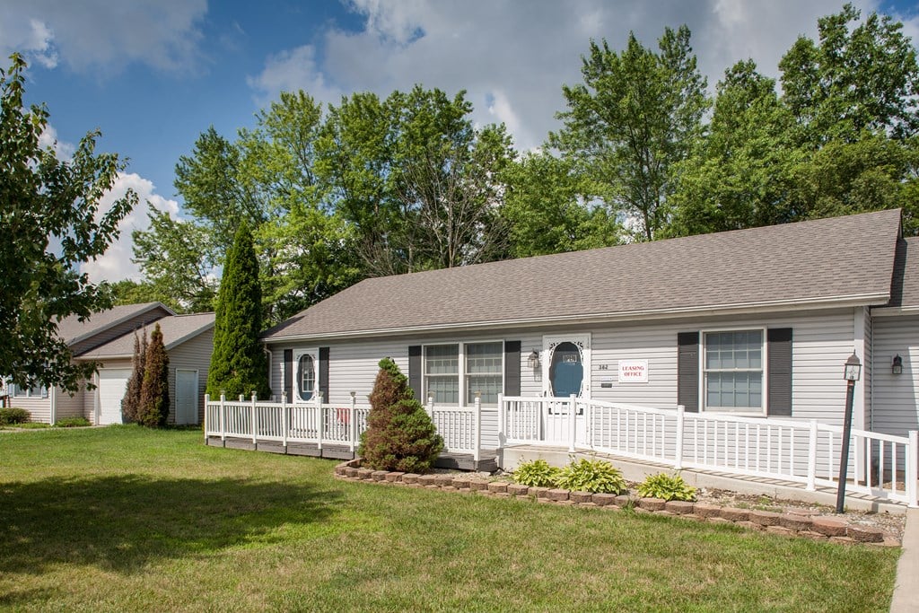 a white house with a white porch and a blue door