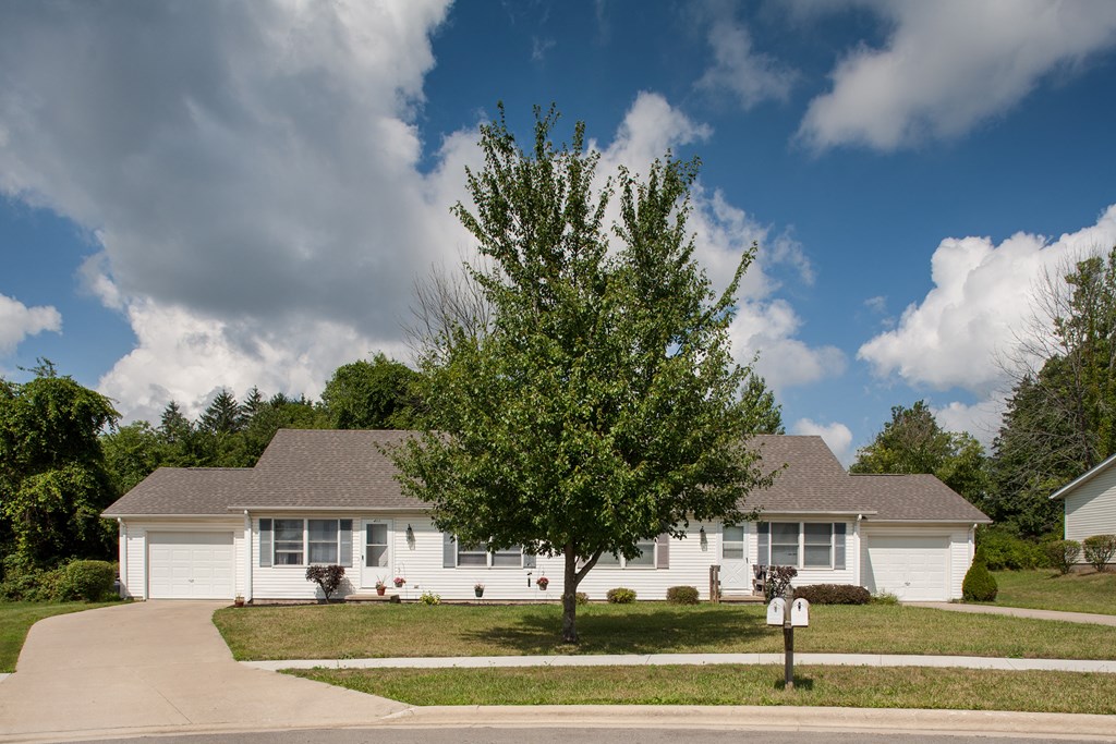 a white house with a tree in front of it