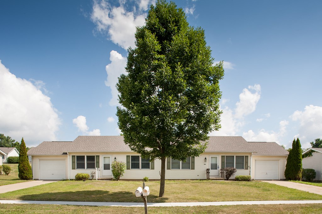 a white house with a tree in front of it