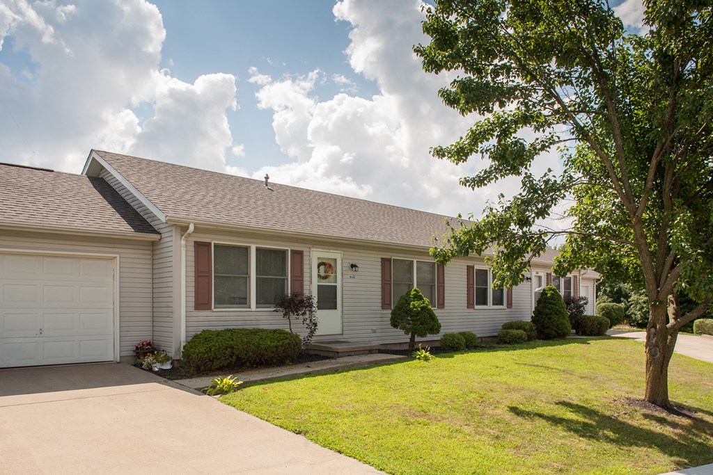 a white house with a lawn and a white garage door